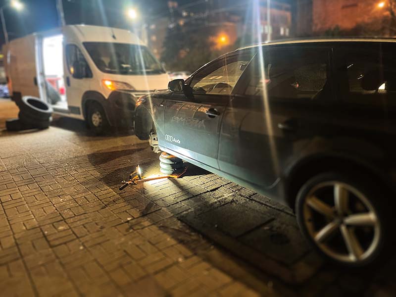 Mobilna wulkanizacja szczecin mobilna naprawa opon w czarnym samochodzie Audi wieczorem na drodze