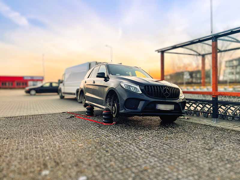 Mobilna wulkanizacja szczecin mobilna wymiana opon w czarnym samochodzie Mercedes SUV na parkingu sklepowym